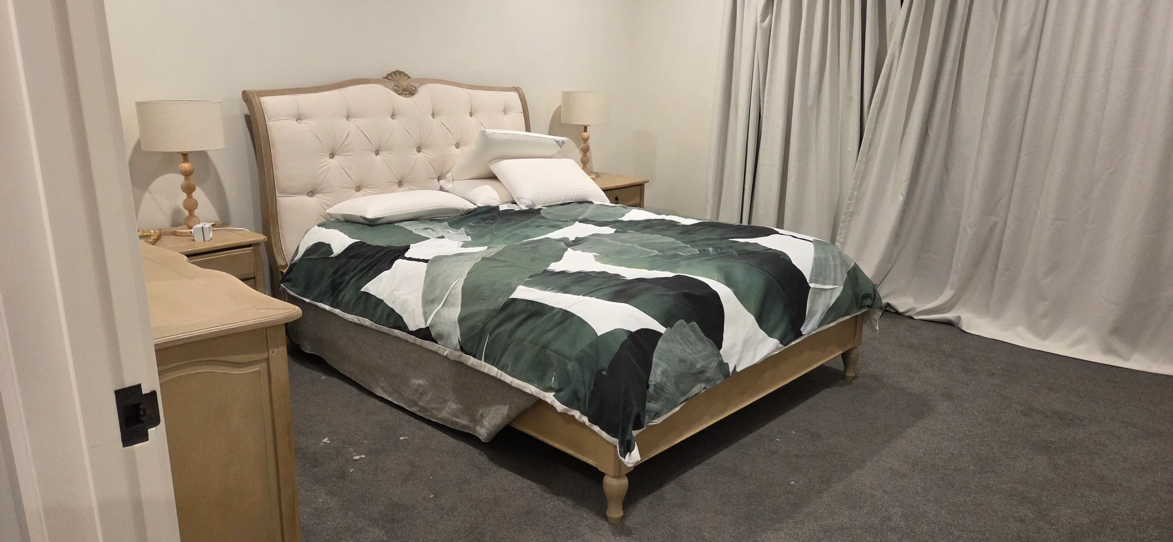 Double bed with an upholstered headboard, bedside tables and lamps